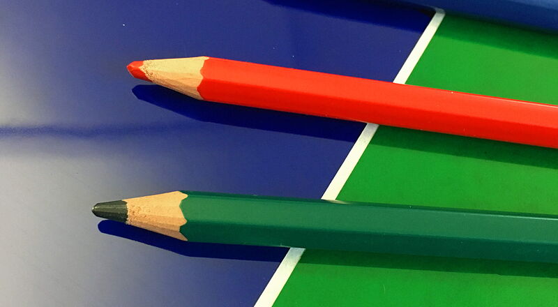 Verschiedenfarbige Buntstifte auf farbigem Hintergrund